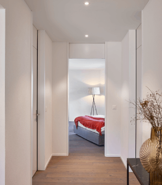 Flur mit Einbauschränken; geöffnete Türen mit Blick ins Schlafzimmer – viel Stauraum.